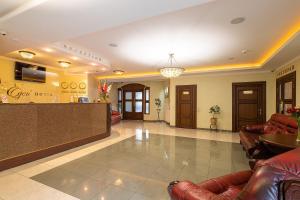 a lobby of a hotel with leather chairs and a counter at Edem Hotel Lviv in Lviv