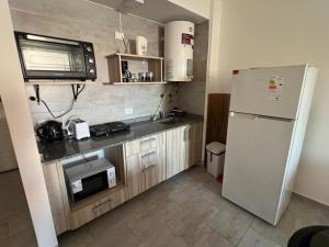 a kitchen with a refrigerator and a microwave at Estudio Playa in Miramar