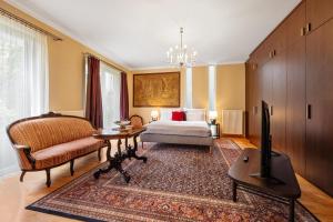 ein Schlafzimmer mit einem Bett, einer Couch und einem Tisch in der Unterkunft Hotel ANTARES in Bratislava