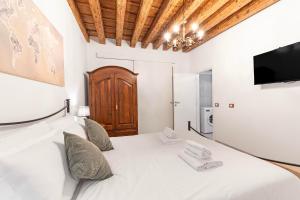 a bedroom with a white bed and a flat screen tv at Armida Flat by Fenix in Venice