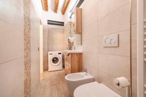 a bathroom with a toilet and a washing machine at Armida Flat by Fenix in Venice +35 photos