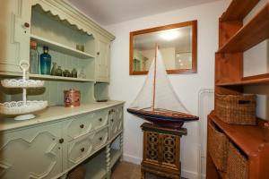 a room with a dresser with a toy sailboat on it at Sunnybrae Cottage in Tintagel