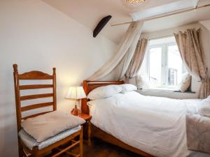 a bedroom with two beds and a window at Sunnybrae Cottage in Tintagel