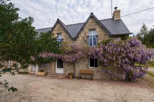 a house with a wreath of purple flowers on it at Ty Kerouannec in Guilligomarcʼh