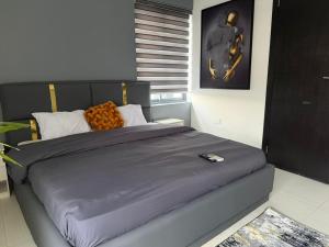 a bedroom with a large bed with a blue comforter at Max Heights, 2 Captivating Bedrooms in Ikeja +41 photos