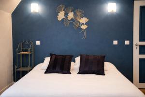 a bedroom with a white bed with two pillows at L'Harmony in Saint-Arnoult-en-Yvelines +4 photos