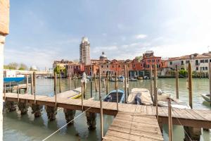 a dock with a boat in the water next to buildings at Armida Flat by Fenix in Venice
