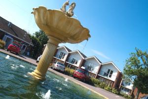 a large statue in the water in front of some houses at The Harbour Post at Waterside Park in Corton