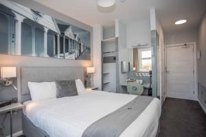 a bedroom with a large white bed and a bathroom at The Harbour Post at Waterside Park in Corton