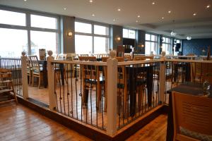 a restaurant with tables and chairs and a fence at The Harbour Post at Waterside Park in Corton