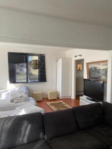 a living room with a couch and a flat screen tv at Central Villa Hultsfred Vimmerby in Hultsfred