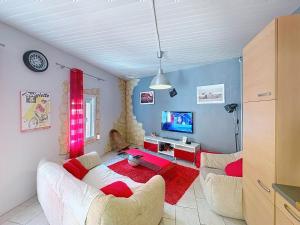 a living room with a white couch and a tv at La Petite Riau in Seillonnaz