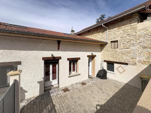 a brick house with a courtyard in front of it at La Petite Riau in Seillonnaz