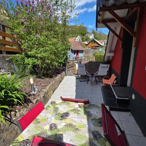 a patio with chairs and a table on a house at Gîte Vallée de Munster 3 étoiles chez Flavie & Ludo in Muhlbach-sur-Munster