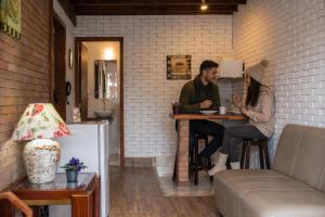 a man and a woman sitting at a table at Villa Belle Chalés in Campos do Jordão
