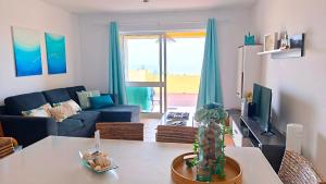 a living room with a blue couch and a table at Thelighthouse Porto Santo in Porto Santo