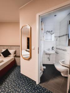 a bathroom with a bed and a sink and a mirror at Hotel Kühns Mühle in Oestrich-Winkel +119 photos