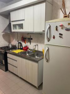 a kitchen with a white refrigerator and a sink at Roberto in Posadas