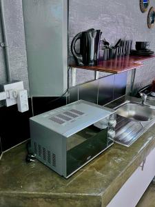 a microwave sitting on a counter next to a sink at Craftsmanship Unit 235 in Johannesburg +4 photos