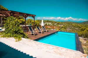 a swimming pool with two chairs and an umbrella at Marepromo Žirje in Žirje +75 photos