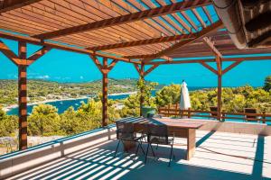 a deck with a table and chairs and a view at Marepromo Žirje in Žirje