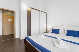 a bedroom with two beds with blue pillows at Lotus Oliva Apart in Premantura
