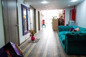 a living room with a blue couch and a hallway at Hotel Veneton Dosquebradas in Dosquebradas