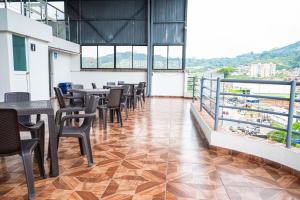 a restaurant with tables and chairs and a balcony at Hotel Veneton Dosquebradas in Dosquebradas
