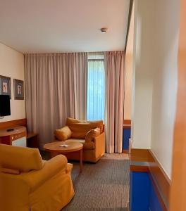 a living room with two couches and a television at Hotel Torresport in Torrelavega