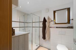 a bathroom with a shower with a glass door at Ferienwohnung Hochspessart in Rothenbuch +25 photos
