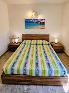 a bedroom with a large bed with a colorful comforter at Serendipity, La Caletta in La Caletta