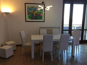 a dining room with a white table and chairs at Magellano Room in Verona