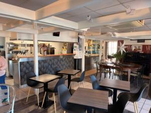 a restaurant with tables and chairs and a bar at Brit Hotel Essentiel Pau Lescar in Lescar