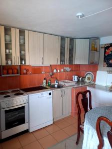 a small kitchen with white appliances and a table at Bay View Escape in Igalo
