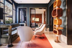 a living room with a couch and chairs at Hotel Montalembert in Paris +71 photos