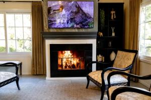a living room with a fireplace with a painting above it at Lapônia Hotel Gramado in Gramado