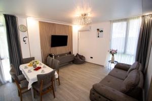 a living room with a table and a couch at Magnetoria 3 BR House in pine forest - 3 mins to the sea in Urekis Sadguri