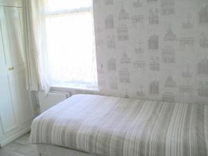 a bedroom with a bed and a window at Liverpool Airport Rooms in Speke