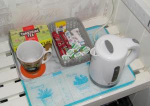 a shelf with a coffee cup and a mug at Liverpool Airport Rooms in Speke
