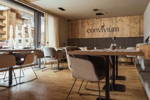 a restaurant with tables and chairs and a sign that reads comium at Paradise Lodge in Livigno