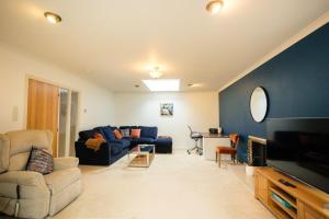 a living room with a couch and a tv at 54a Albert Street, Kirkwall, Orkney - OR00603F in Kirkwall