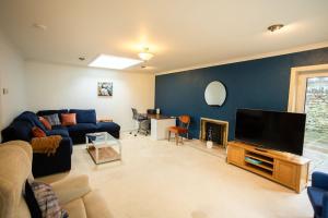 a living room with a couch and a flat screen tv at 54a Albert Street, Kirkwall, Orkney - OR00603F in Kirkwall