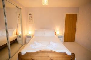 a bedroom with a bed with two towels on it at 54a Albert Street, Kirkwall, Orkney - OR00603F in Kirkwall +5 photos