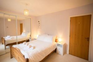a bedroom with a large bed and a mirror at 54a Albert Street, Kirkwall, Orkney - OR00603F in Kirkwall