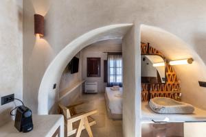a bathroom with a bed and a sink in a room at Meroviglia Boutique Hotel in Imerovigli