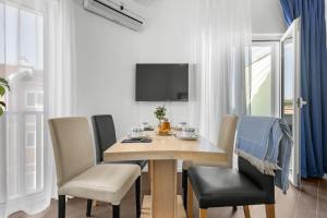 a dining room with a table and chairs and a tv at Lotus Oliva Apart in Premantura