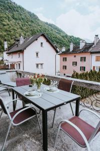 a table and chairs on a balcony with buildings at The Nucleo House Experience in Maggia