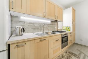 a kitchen with wooden cabinets and a sink at Casa Due Spighe in San Sperate