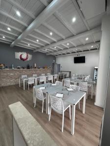 a dining room with white tables and white chairs at Hotel GANS in Cascia