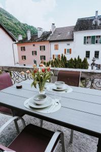 a table with two plates and a vase of flowers at The Nucleo House Experience in Maggia